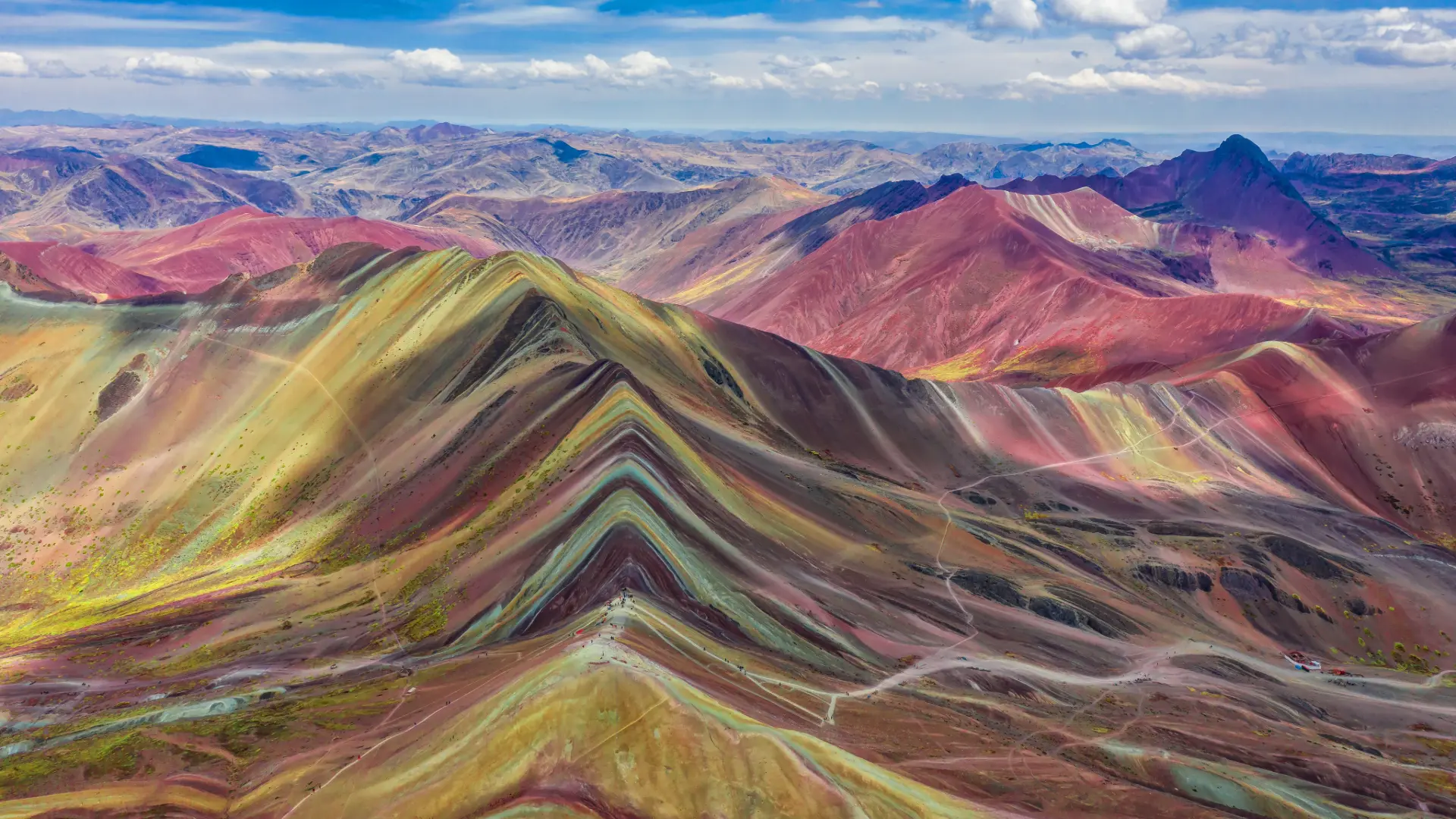 Happy tourists celebrating at the top of Rainbow Mountain