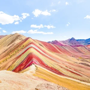 Hikers reaching Rainbow Mountain summit during Seven Colors Tours