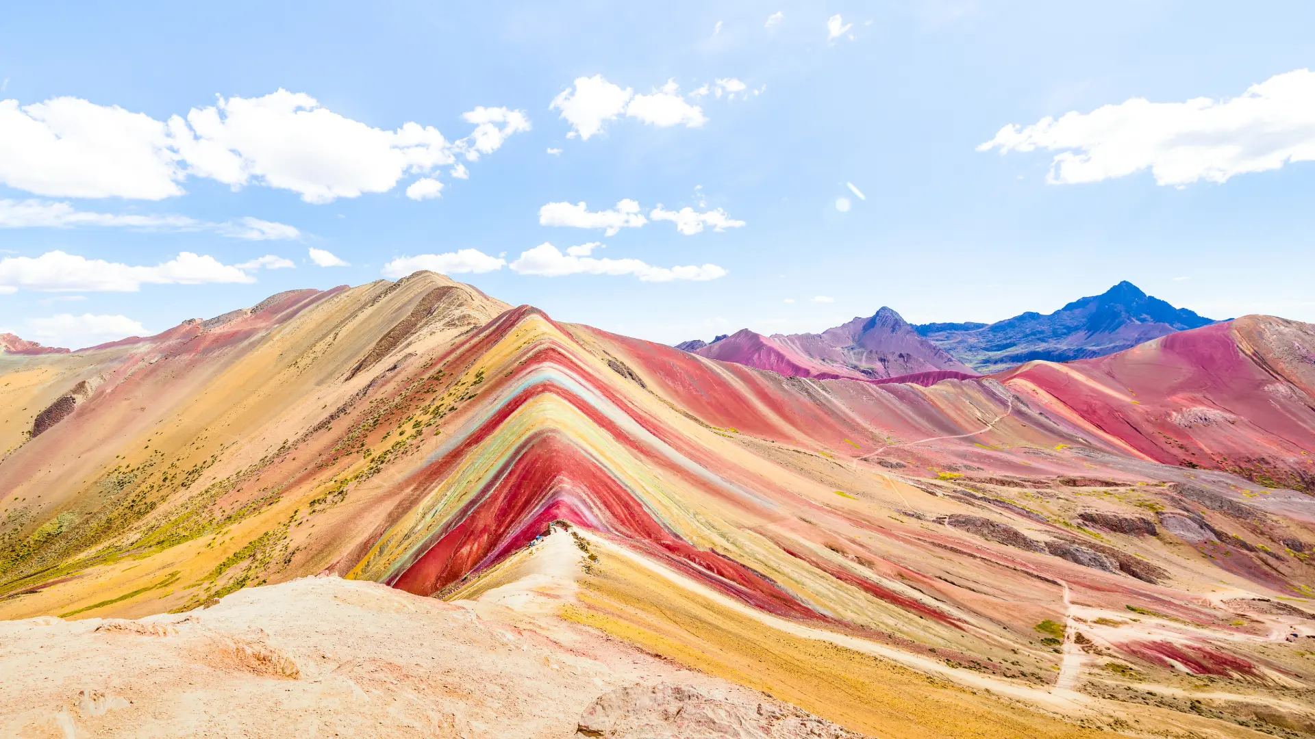 Hikers reaching Rainbow Mountain summit during Seven Colors Tours