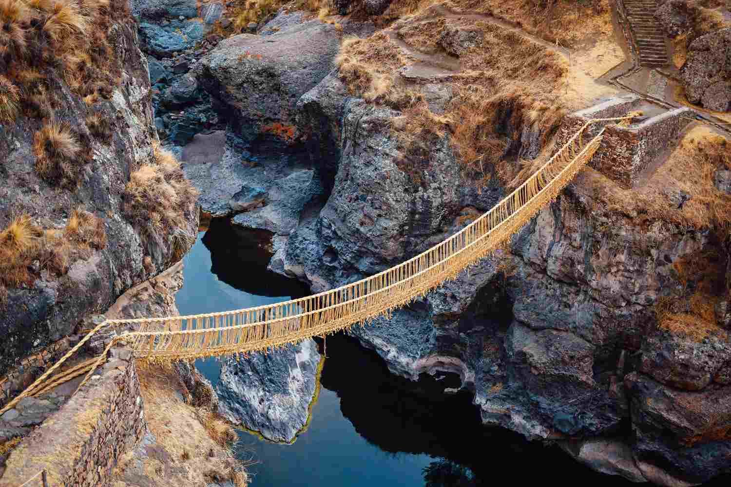 Locals rebuilding the Qeswachaka rope bridge with traditional fibers
