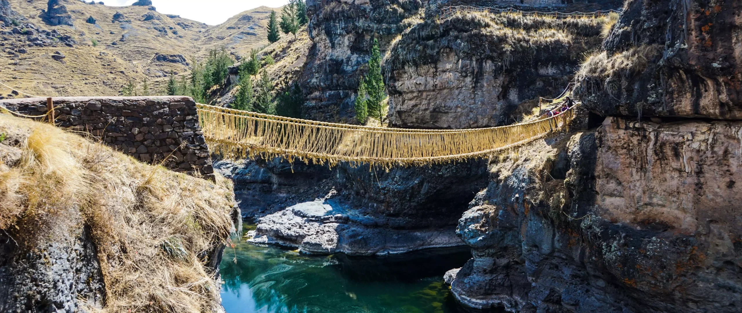 Travelers crossing the Qeswachaka rope bridge in Peru