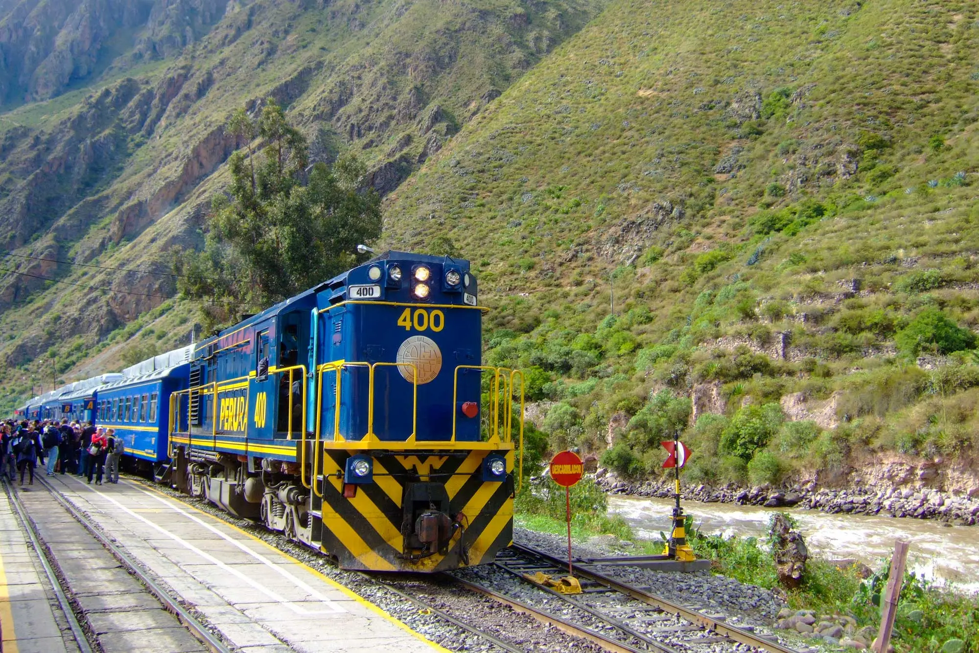 A blue and yellow train at the station ready for the trip to Machu Picchu.